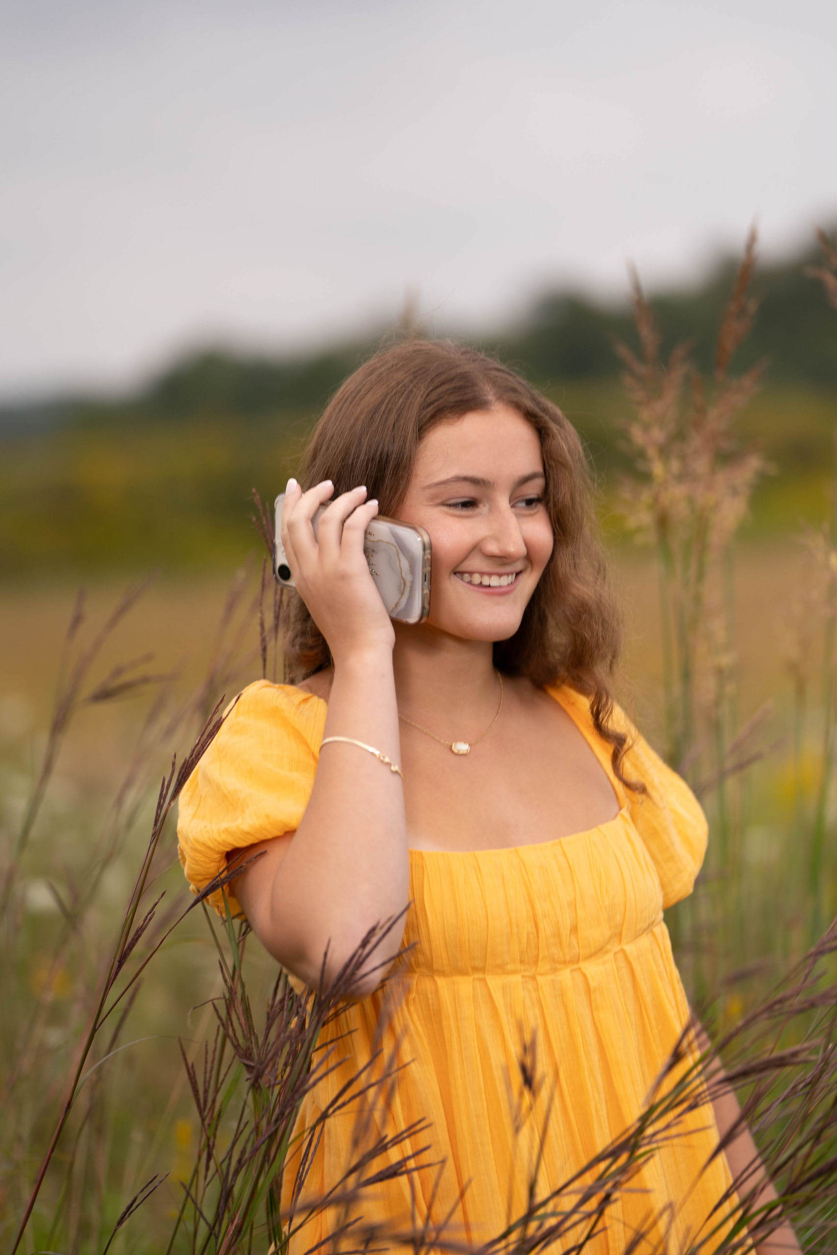 Sweet Studios Senior Photographer on Cell phone in Field